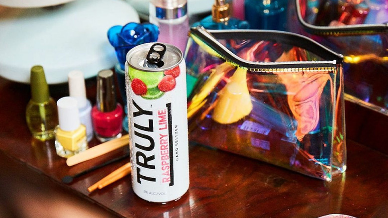 a can of TRULY raspberry lime sitting on a makeup table