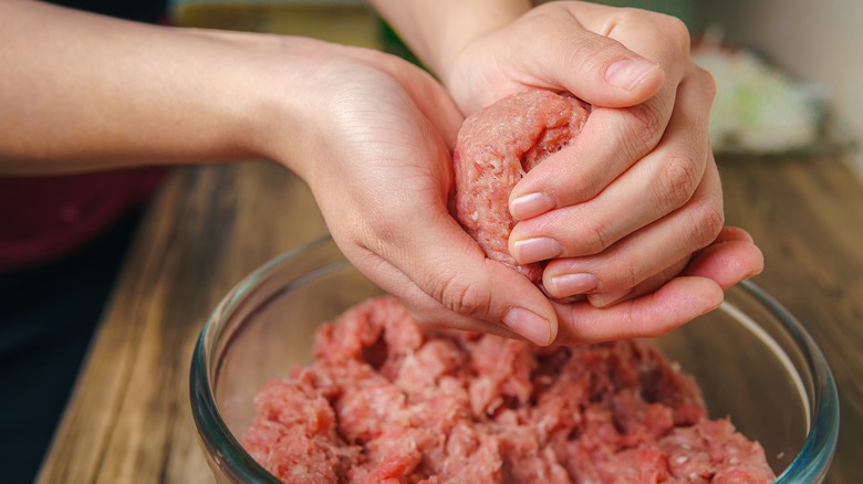 Person shaping burgers patties