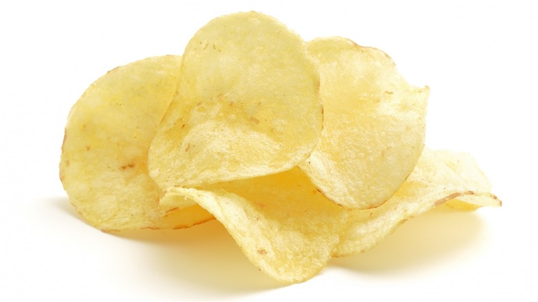 Handful of potato chips on white background