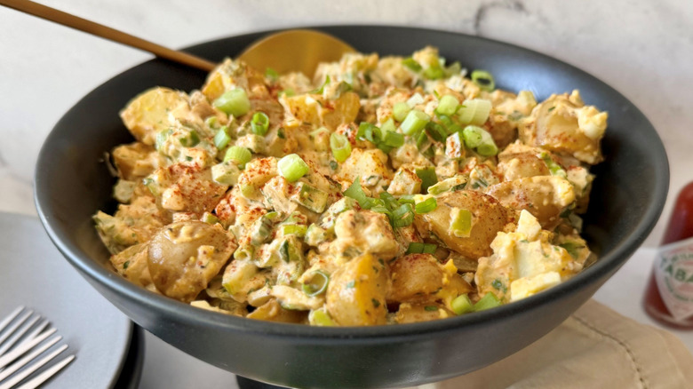 Cajun potato salad in bowl with spoon