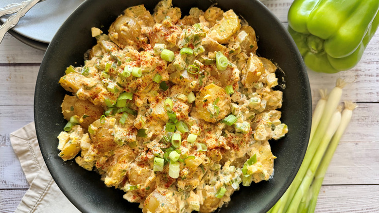 Cajun potato salad in bowl topped with green onions