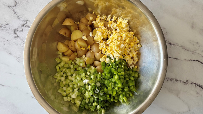 Potatoes, diced hard boiled egg, diced bell pepper, and diced celery in bowl