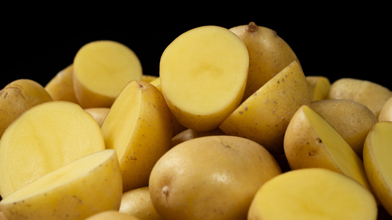 A pile of potatoes, some cut in half