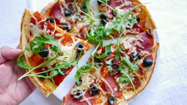 hand holding pizza slice