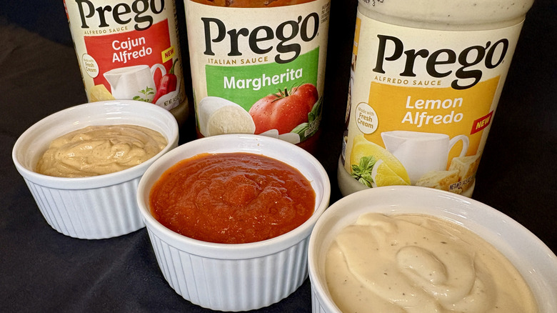 Three Prego sauces in dishes with jars behind