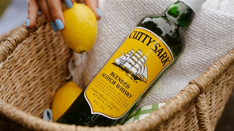 Bottle of Cutty Sark in basket with lemons