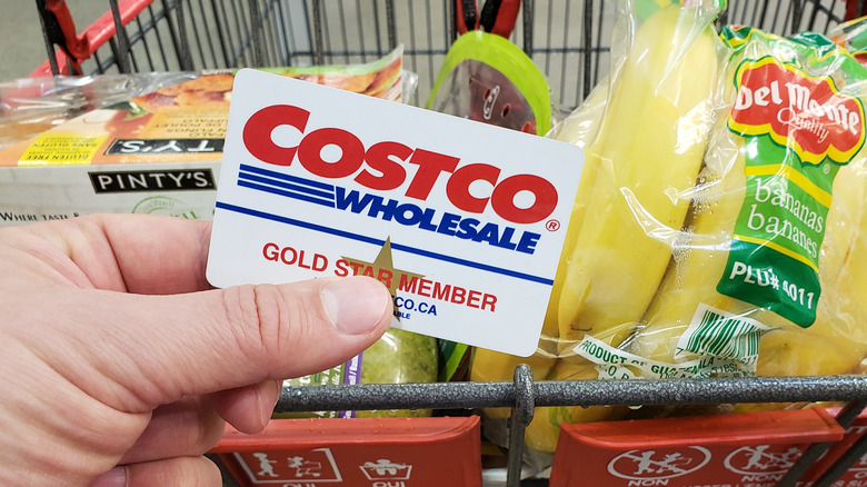 holding costco card over grocery cart