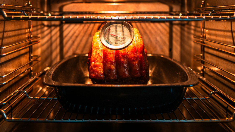 Prime rib roast in oven with meat thermometer.