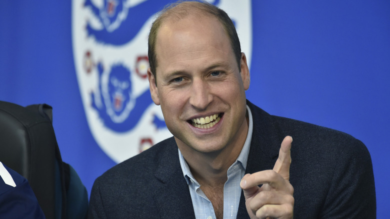 Prince William smiling and pointing