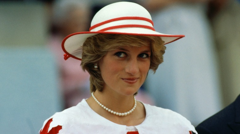 Princess Diana in a red and white dress and hat.