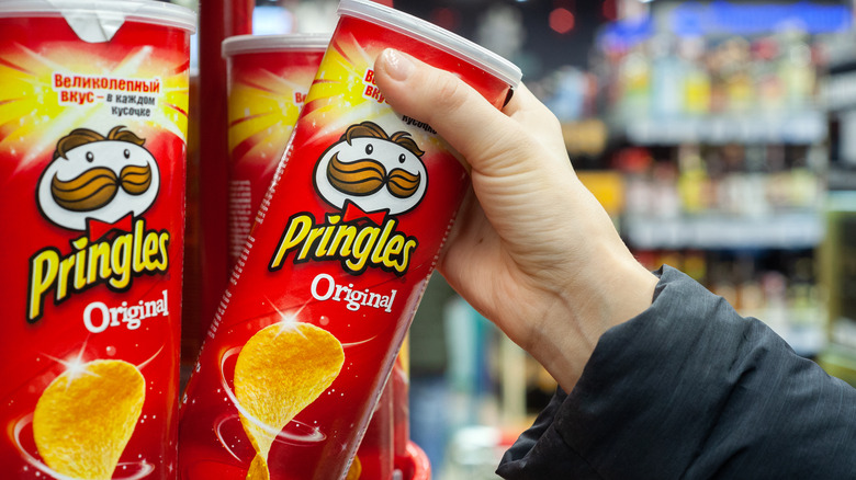 Person grabbing a can of potato chips