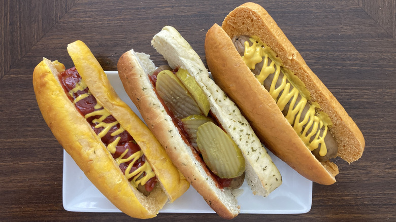 Three hot dogs with Pringles buns and mustard, ketchup, and pickles