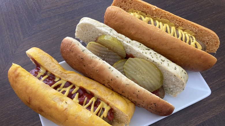 Three hot dogs using Pringles flavored buns topped with mustard and pickles