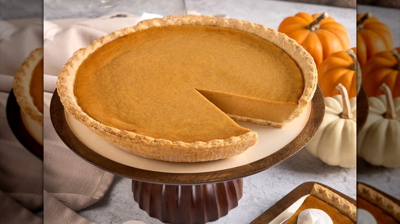 Sam's Club Member's Mark pumpkin pie on a serving tray surrounded by pumpkins and whipped cream