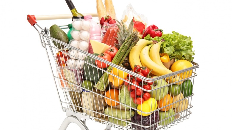 grocery cart full of groceries on white background