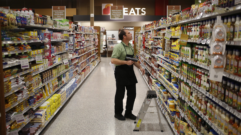 Publix employee in green shirt and black apron