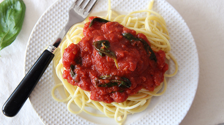 marinara sauce with spaghetti on white plate