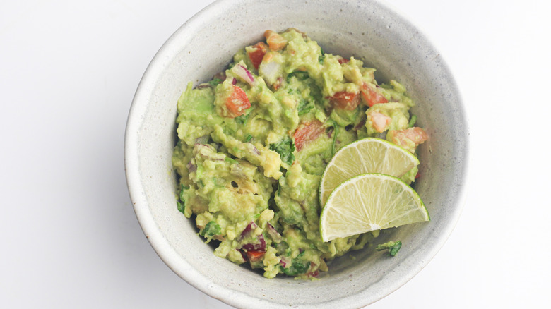 bowl of guacamole, lime garnish