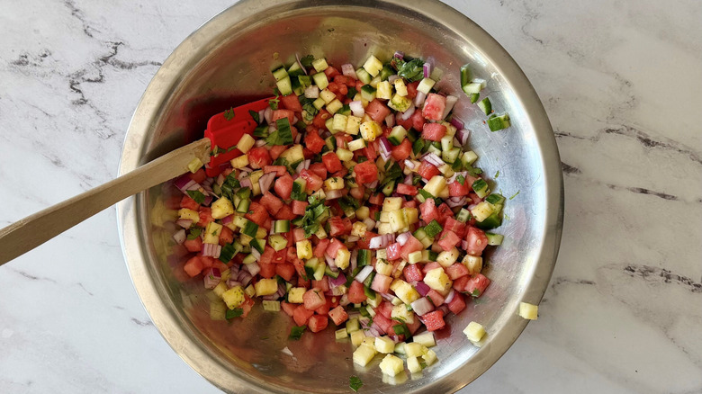 Mixed fruit salsa with rubber spatula in bowl