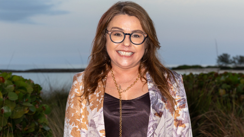 Cooking star Rachael Ray wearing glasses and a floral blazer, grinning at the camera