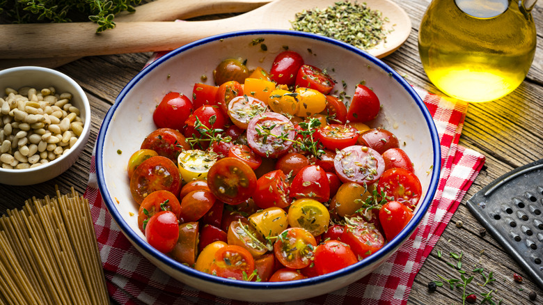A bowl of sliced cherry tomatoes with herbs