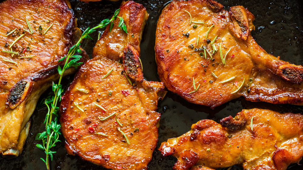 Roasted pork chops on a dark background