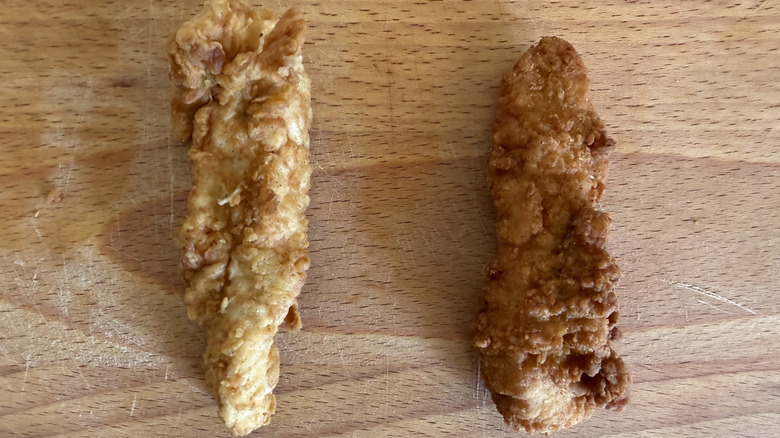 One of each tender from Raising Cane's and Chick-fil-A on a cutting board