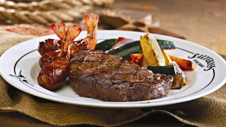 Saltgrass Steak House ribeye on a plate with shrimp and vegetables
