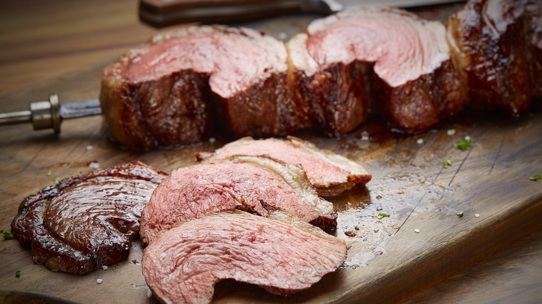 sliced picanha steak sits on wooden cutting board