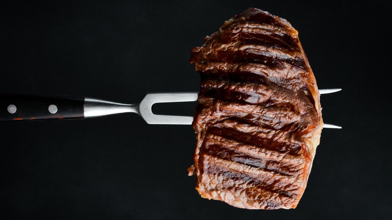 carving fork holds a steak