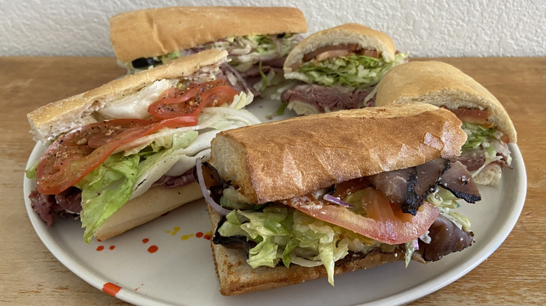 five roast beef sandwiches on a large plate