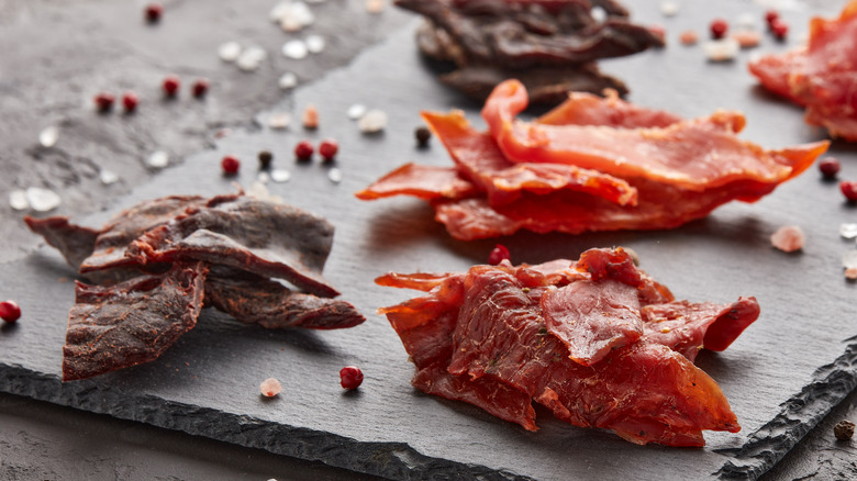 Different types of beef jerky on stone tray