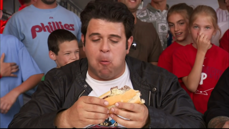 Adam Richman eating a cheesesteak