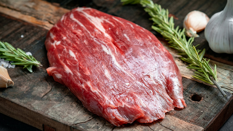 Raw flank steak on board