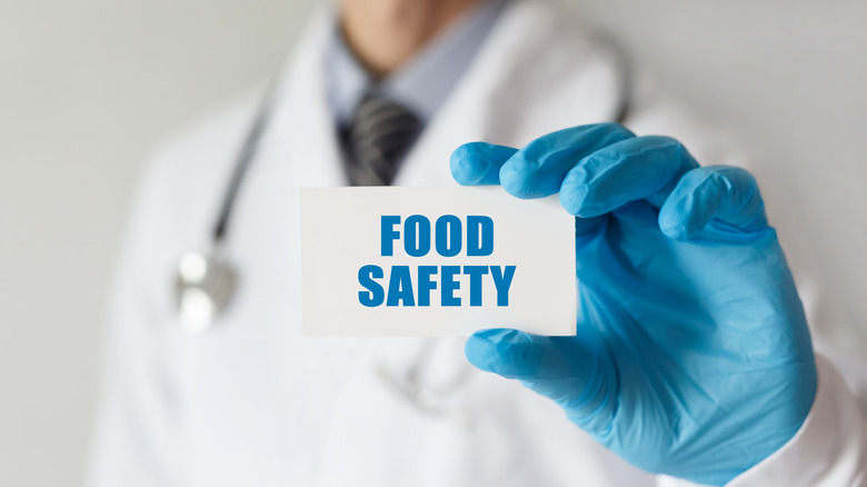 doctor holding food safety card