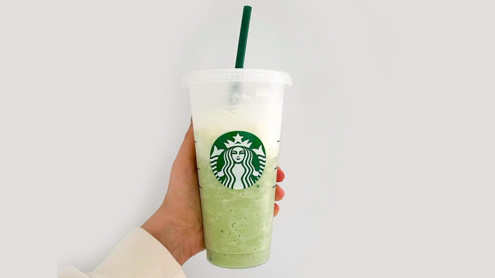 Woman holding an iced matcha latte 