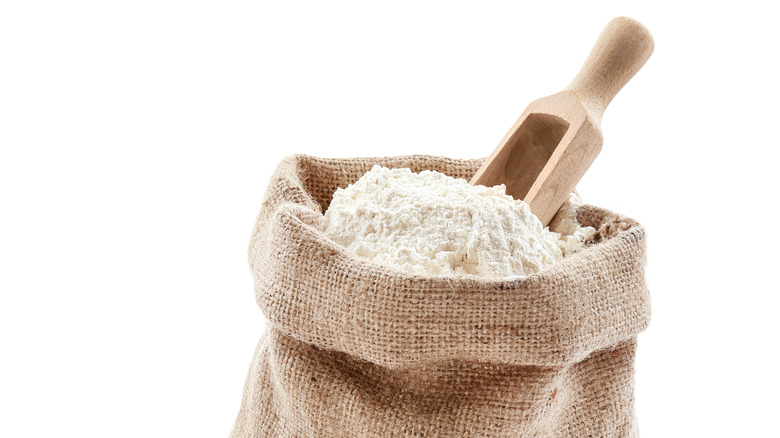 Burlap sack of flour with a wooden scoop