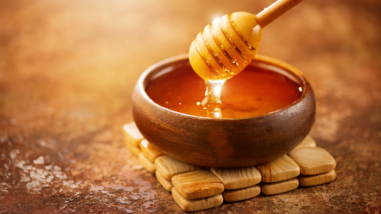 honey and dripper with wooden bowl