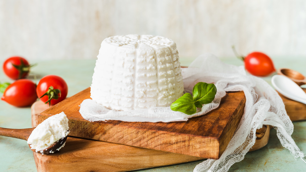 fresh ricotta cheese on a wooden cutting board