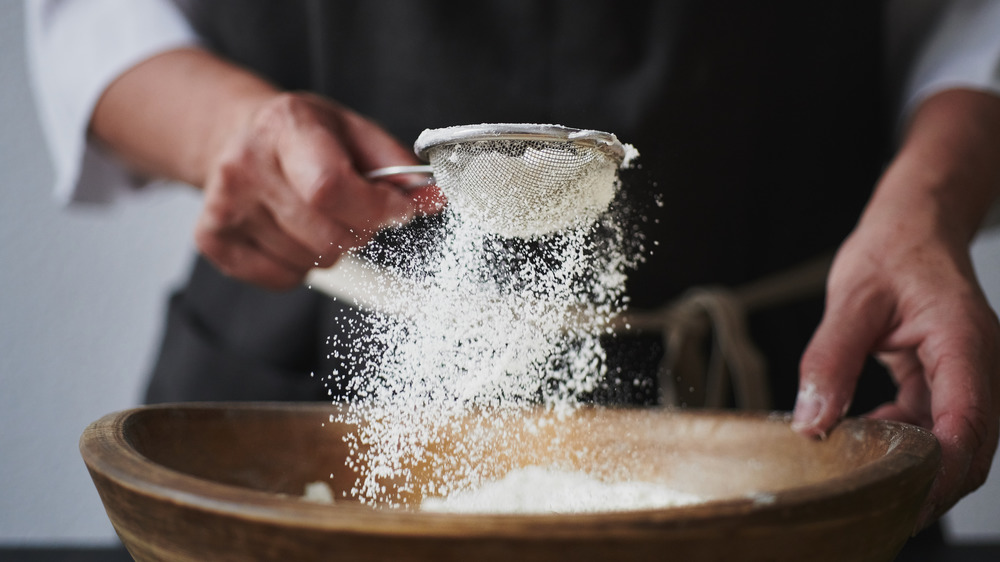 Woman's hands baking with white flour