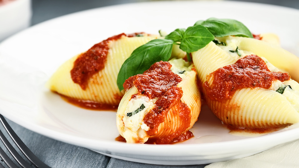 stuffed pasta shells on white plate with red sauce