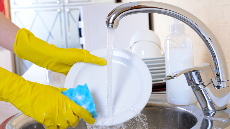 Woman washing dishes in sink