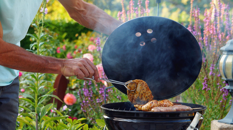 Person getting food from grill