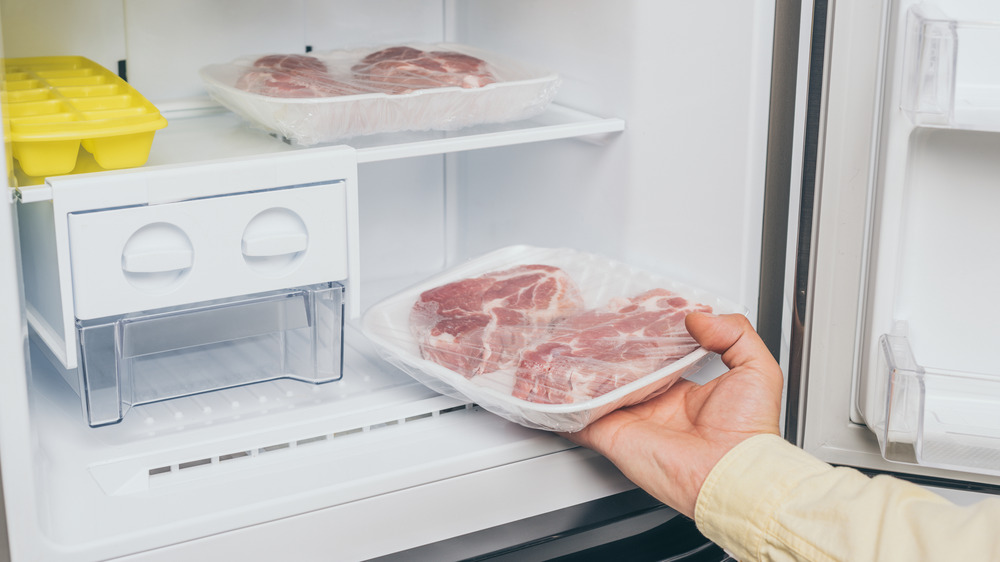 Person taking frozen meat out of freezer