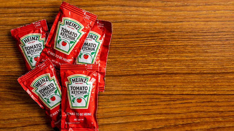 Ketchup packets on a wooden table