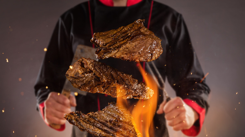 chef cooking steak in flame