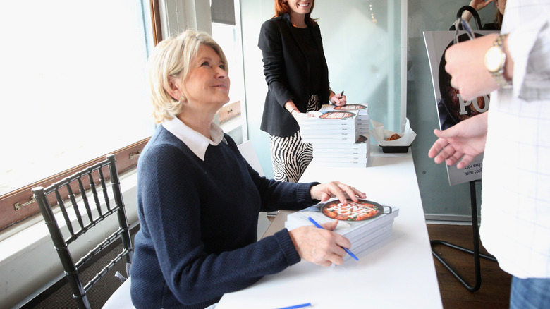 Martha Stewart signing autographs for fans at a publicity event.