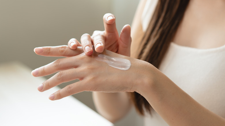 woman applying lotion to hands