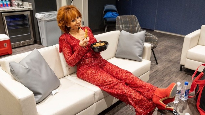 Reba McEntire posing in a glittery red outfit