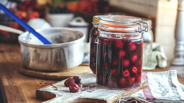 homemade canned jam with pot in background 